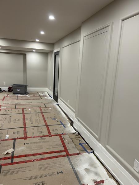 Basement hallway with picture-frame wainscoting and a fluted panel