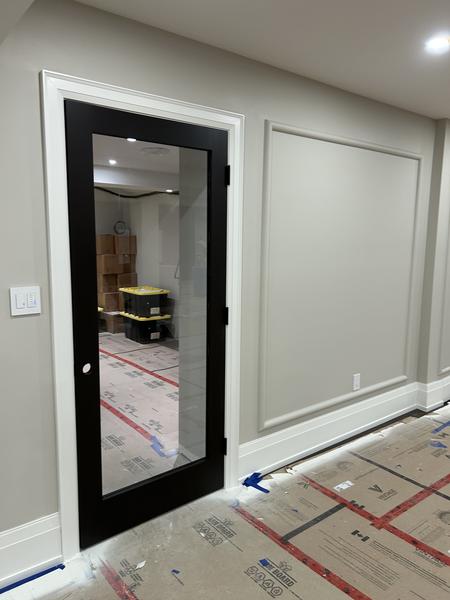 Black glass-panel door with white trim and wainscoting