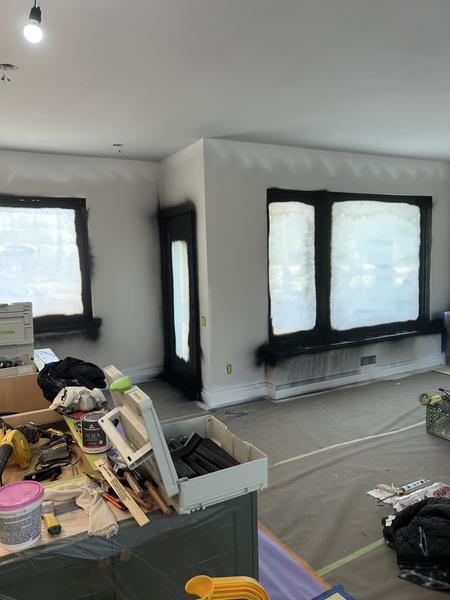 Room with window frames freshly sprayed black and spray equipment