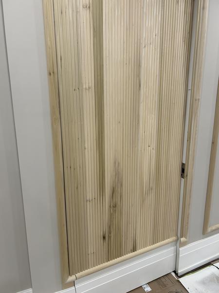 Raw wood fluted panel installed on wall before paint