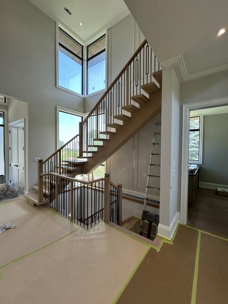 Oak staircase with black iron balusters and tall windows