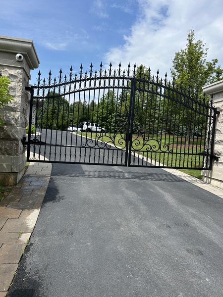Wrought-iron driveway gate refinished in black